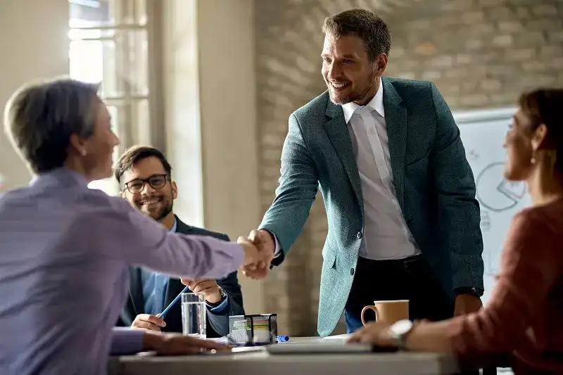 Ethics and Compliance Culture: Fostering a Culture of Ethics and Compliance within an Organization 8 business coworkers shaking hands during meeting office focus is businessman